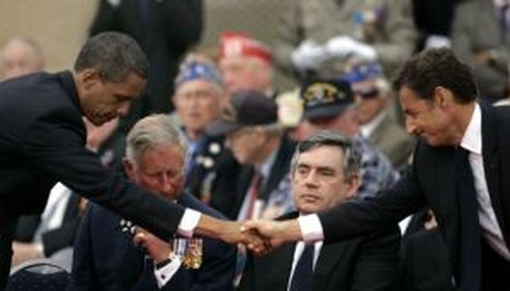 President Barack Obama, left, shakes hands with French President Nicolas Sarkozy, as Britain's Prince Charles and Prime Minister Gordon Brown look on during the 65th anniversary of D-Day in Normandy.