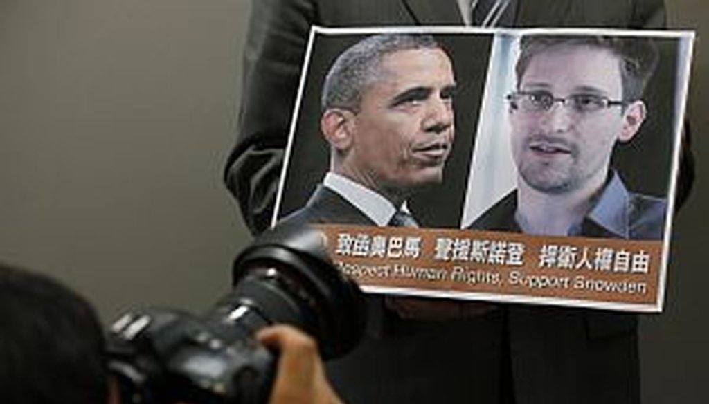 A protestor holds a sign supporting Edward Snowden at a June news conference in Hong Kong. (AP Photo)