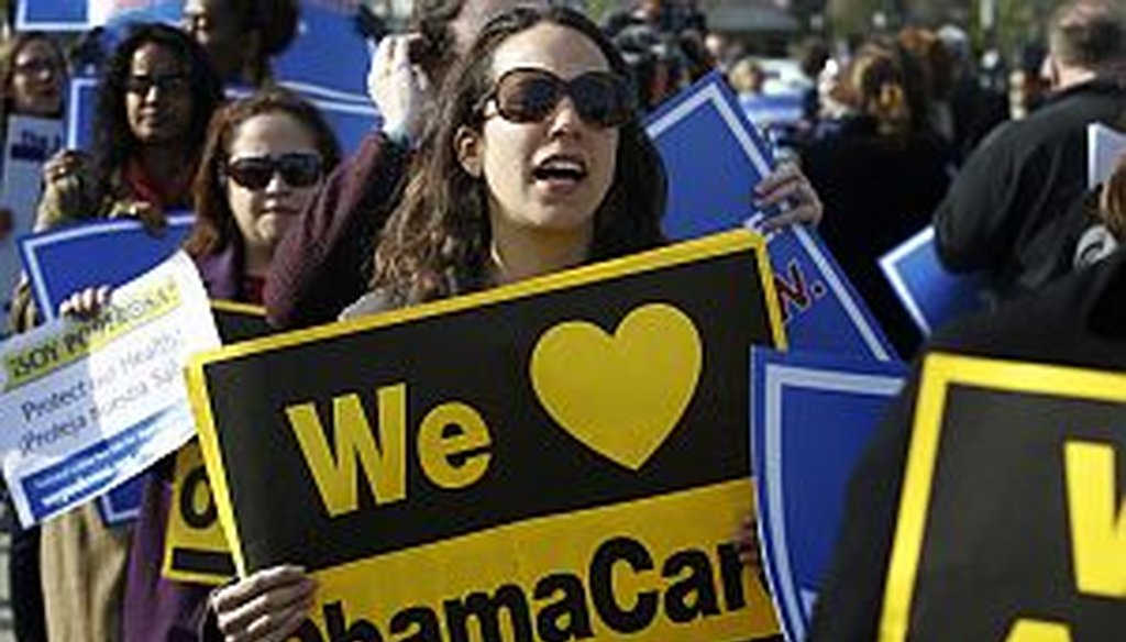 Supporters of health care reform stand in front of the Supreme Court in Washington on March 28, 2012. (AP Photo)