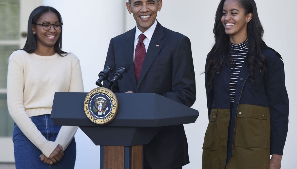 President Barack Obama standing with his daughters, Sasha, left, and Malia, right, as Obama pardons a turkey at the White House on Nov. 25, 2015. (AP)