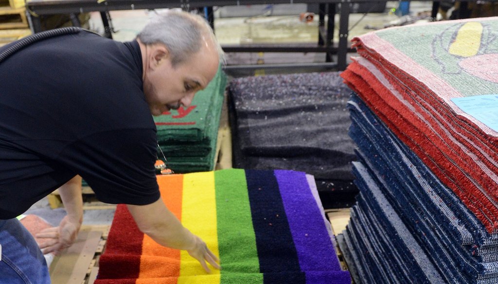 A production manager at Millennium Mats checks one of the printed products at its Suwanee plant in 2012, after the firm reversed its outsourcing efforts and shifted work back to the U.S. from China. Photo by Kent D. Johnson/ AJC.