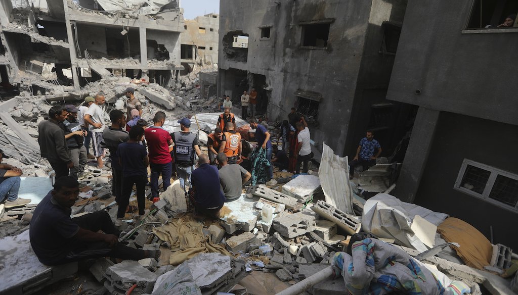 Palestinians look at the destruction after an Israeli strike on a residential building in Nuseirat Refugee Camp, Gaza Strip, May 19, 2024. (AP)