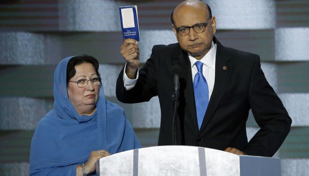 Khizr Khan holds a copy of Constitution of the United States, that he offered to lend to Donald Trump, with his wife Ghazala Khan, during the last day of the Democratic National Convention. (TNS)