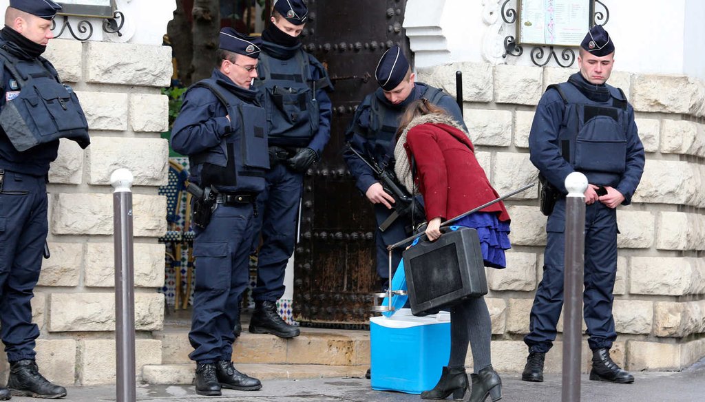 Riot police officers check a woman at the Grand Mosque of Paris, France, Wednesday, Jan. 14, 2015, the day the French satirical newspaper Charlie Hebdo released its first issue after a lethal terrorist attack, (AP)
