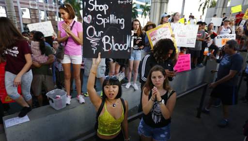 A demonstrator holds a sign saying "Stop Spilling Our Blood" during a protest against guns in Fort Lauderdale, Fla., three days after the school shooting in Parkland, Fla. (Associated Press)