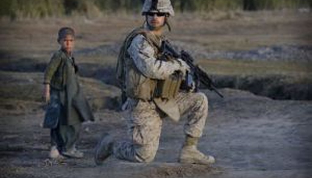 An Afghan boy stands next to a United States Marine during an operation in the volatile Helmand province of southern Afghanistan. For most Americans, a war like the one in Afghanistan tests the traditional boundaries of wartime and peacetime.