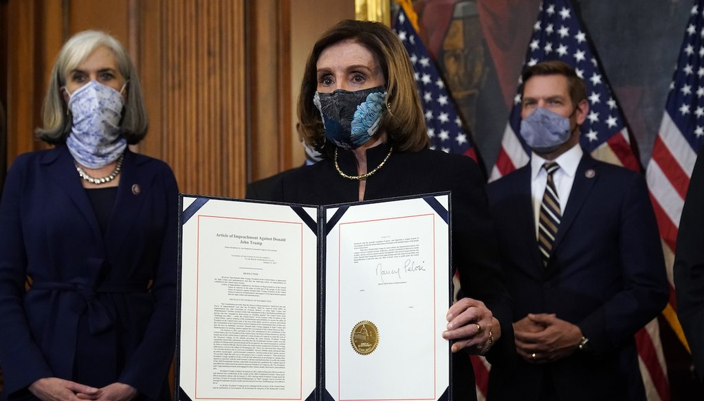 House Speaker Nancy Pelosi of Calif., displays the signed article of impeachment against President Donald Trump. (AP Photo/Alex Brandon)