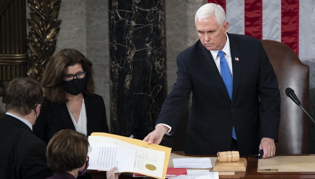 Vice President Mike Pence hands the electoral certificate from the state of Arizona to Sen. Amy Klobuchar, D-Minn., as he presides over a joint session of Congress as it convenes to count the Electoral College votes on Jan. 6, 2021. (AP)