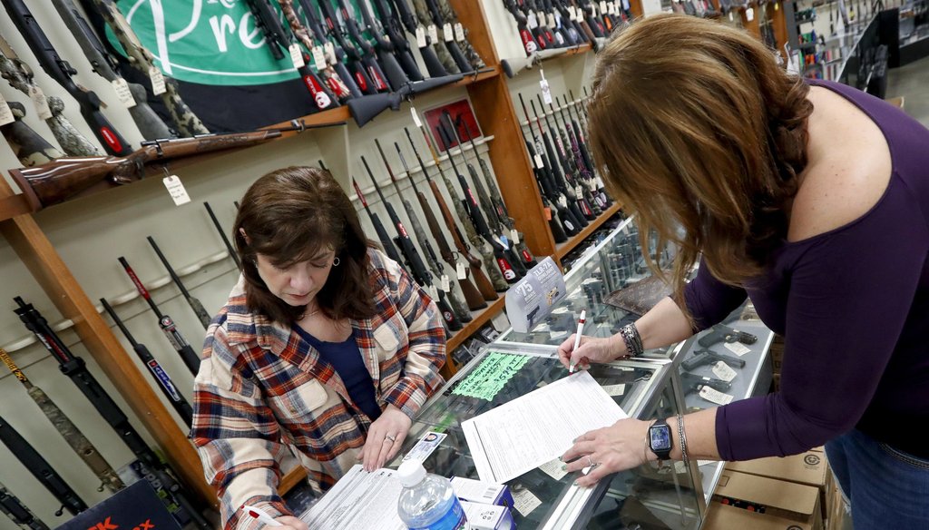 Andrea Schry, right, fills out the buyer part of legal forms to buy a handgun as shop worker Missy Morosky fills out the rest at Dukes Sport Shop in New Castle, Pa. (AP Photo/Keith Srakocic)