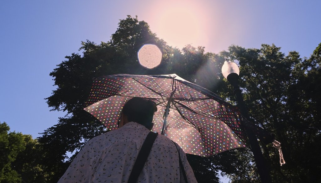 With temperatures hovering near 100 degrees, a woman protects herself from the sun while walking through Boston Common, June 24, 2025, in Boston. (AP)