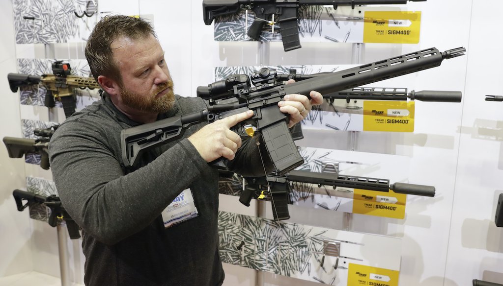 A person tries out an AR-15 from Sig Sauer in the exhibition hall at the National Rifle Association Annual Meeting in Indianapolis on April 27, 2019. (AP)