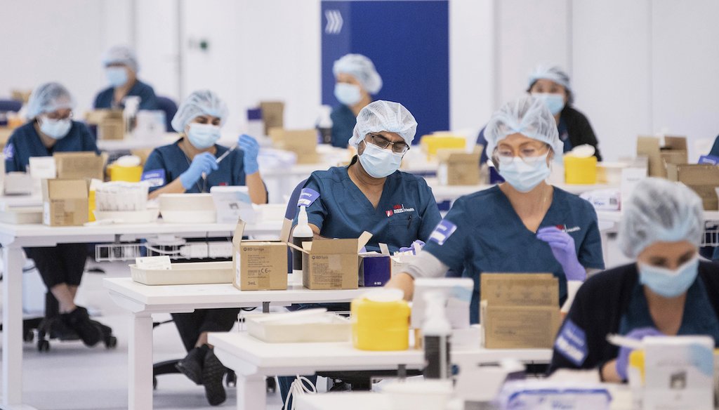 This file photo shows technicians preparing Pfizer vaccines at the COVID-19 Vaccination Centre in Sydney, Australia, on May 10, 2021. (AP Images)