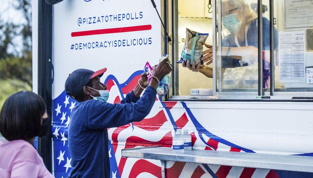 A man receives free snacks from the Pizza to the Polls food trucks on site at an early voting location, Thursday, Oct. 29, 2020, in Atlanta. (AP)
