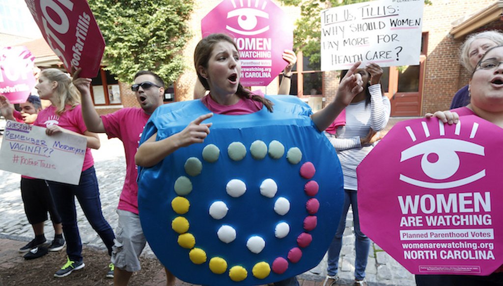 Emily Callen of Raleigh, center, along with other protesters with Planned Parenthood Votes, chant in Raleigh on October 1, 2014. 