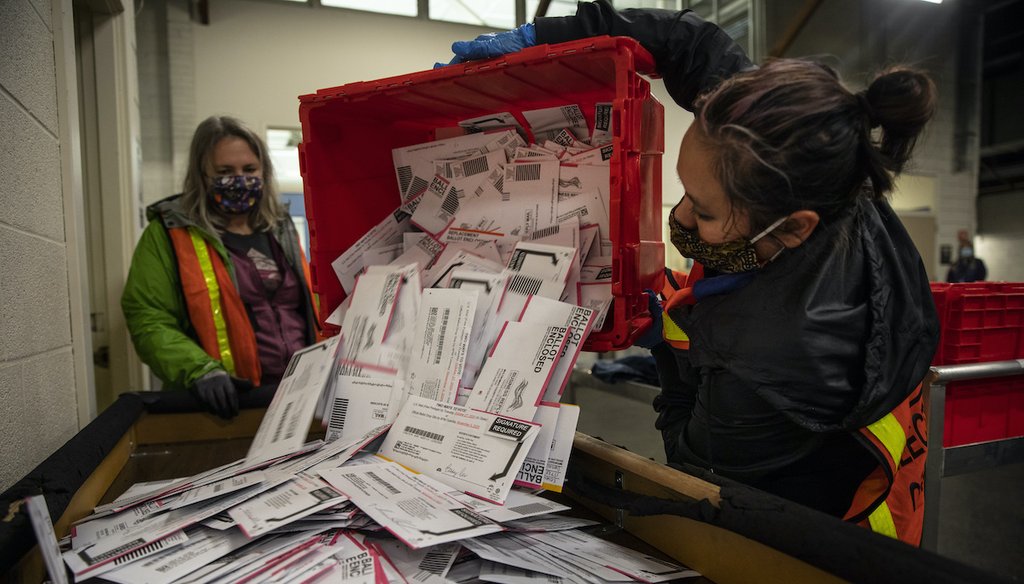 Election worker Kristen Mun from Portland empties ballots from a ballot box at the Multnomah County Elections Division, Tuesday, Nov. 3, 3030 in Portland, Ore. (AP)