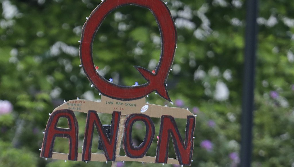 A sign supporting QAnon is hoisted at a May 14, 2020, protest rally in Olympia, Wash. (AP)