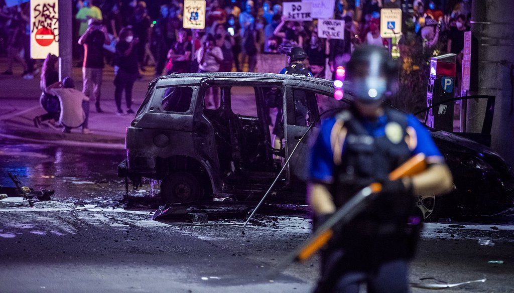 PD stand guard as Austin Fire Department put out a car fire under Interstate 35 freeway in Austin Texas. Demonstrators protest over the police killing of George Floyd Saturday, May 30, 2020.[RICARDO B. BRAZZIELL/AMERICAN-STATESMAN]