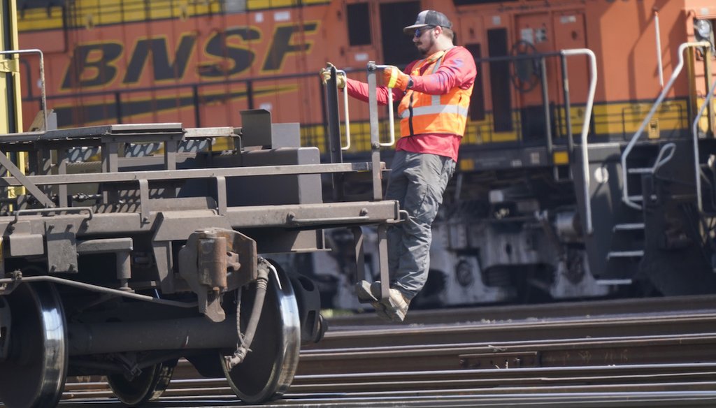 A worker rides a rail car at a BNSF rail crossing in Saginaw, Texas, on Sept. 14, 2022. (AP)