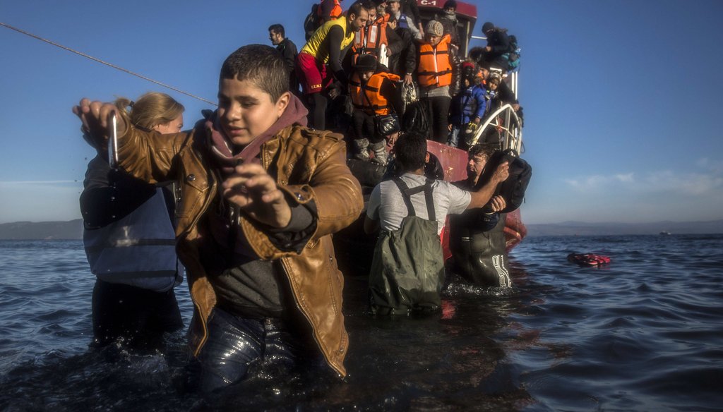 Refugees and migrants, mostly from Syria and Iraq, disembark from a vessel at the northeastern Greek island of Lesbos. (AP)