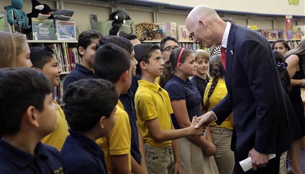 Florida Gov. Rick Scott, right, greets students at the Dr. Carlos J. Finlay elementary school, Monday, June 1, 2015, in Miami. (AP Photo/Lynne Sladky)