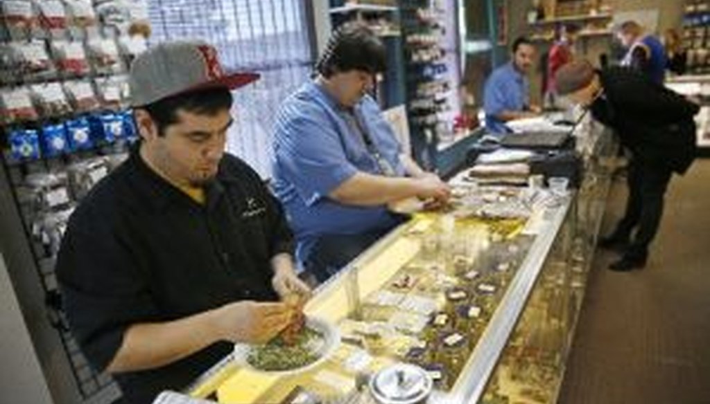 Employees roll joints behind the sales counter at Medicine Man marijuana dispensary in Denver, Colo. Recreational pot became legal this year. (AP)