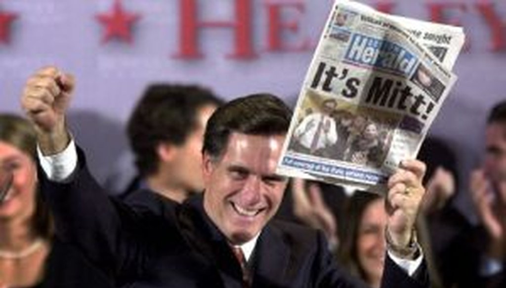 Mitt Romney displays a newspaper declaring his victory in the Massachusetts governors race on Nov. 5, 2002. As a presidential candidate in 2012, he touted his fiscal record as governor.
