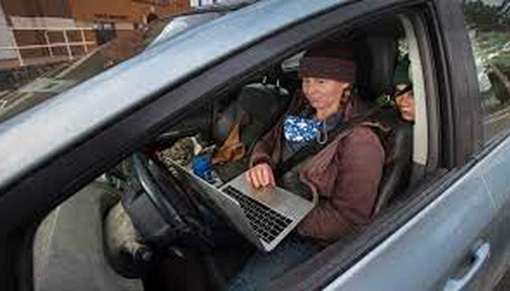 Kat Becker fires up her laptop with her son, Ted, looking over her shoulder in downtown Athens in Marathon County. Internet service is slow and cell service is spotty, so Becker will park downtown and use Wi-Fi from a public facility. (Mark Hoffman/MJS)