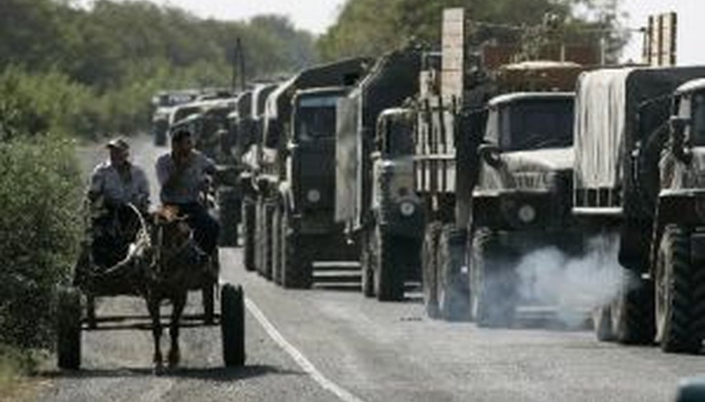 A Russian military convoy moves past a horse-drawn cart with local residents outside Gori, Georgia, on Aug. 13, 2008. (Associated Press)