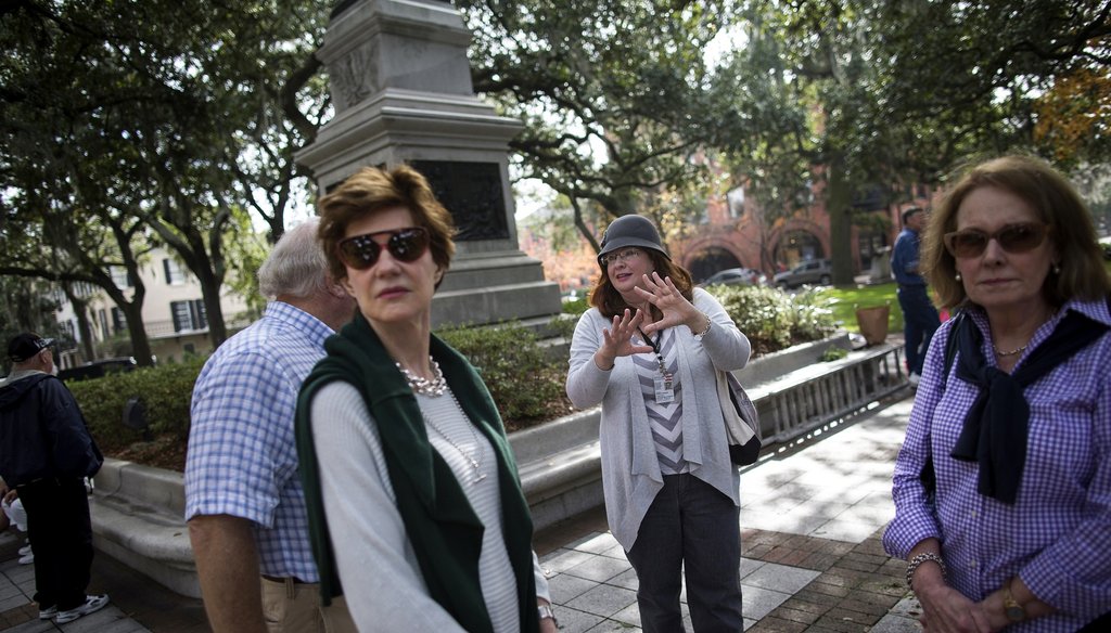 Tourists listen to a guide describe the history at Savannah's Madison Squre. Photo by the New York Times