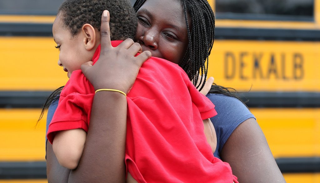 LaTrease Akins rushes off hugging her 5-year-old son Mark Wheeler after being reunited following the shooting incident at McNair Discovery Learning Academy in August 2013. Photo by Ben Gray/AJC