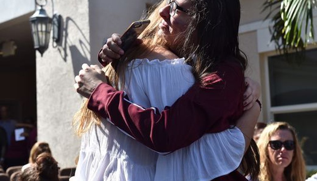Friends embrace in tears before the start of a community prayer vigil for Marjory Stoneman Douglas High School shooting victims. (Eric Hasert/USA Today Network)