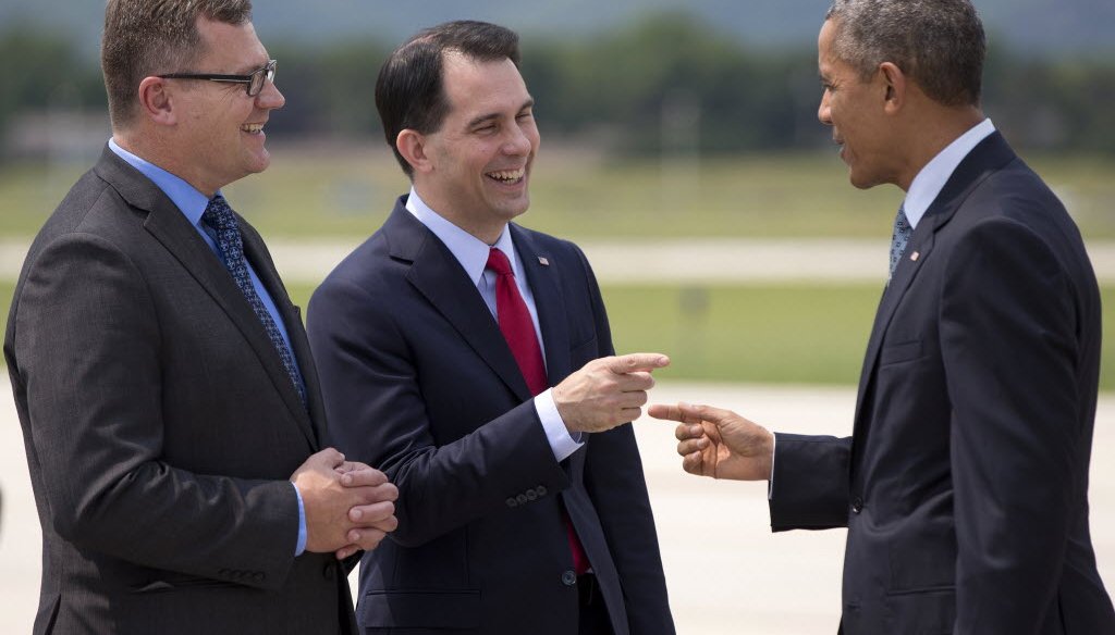 President Barack Obama is greeted by Wisconsin Gov. Scott Walker (middle) and La Crosse, Wis., Mayor Tim Kabat as he arrives at a La Crosse airport on July 2, 2015. Walker is expected to announce his run for president on July 13, 2015. (AP photo)