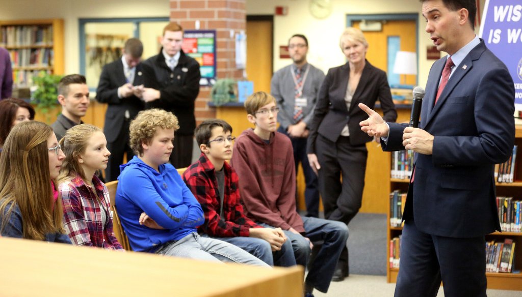 Gov. Scott Walker, appearing here at a middle school in Platteville in February 2017, is criticized for cutting aid to schools but nevertheless claims he has made a "record investment" in them. (Associated Press)