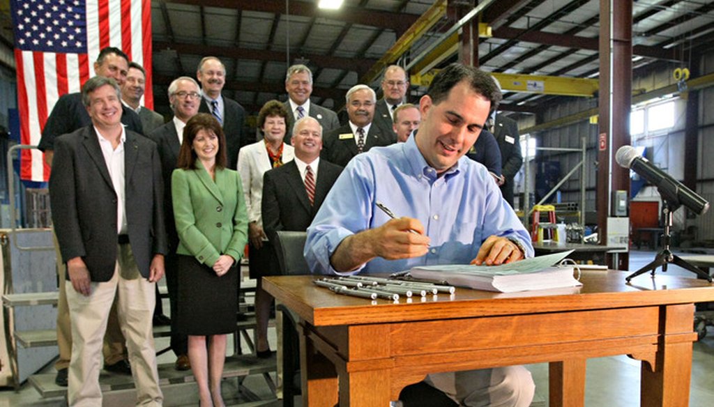Wisconsin Gov. Scott Walker signed his first state budget, for 2011-'13, at a manufacturing facility. (Michael Sears/Milwaukee Journal Sentinel)