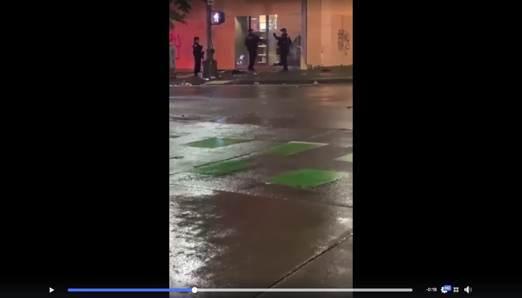 This is a screenshot from a video showing a Seattle police officer trying to gain entry to a building.