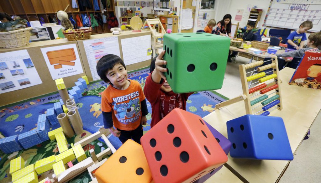 Daniel O'Donnell, left, looks on as William Hayden sends large blocks flying at the Creative Kids Learning Center,in Seattle. (AP)