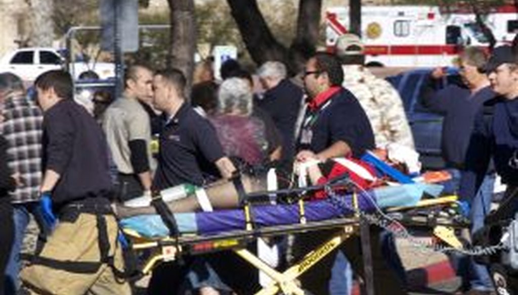 Emergency personnel use a stretcher to carry a shooting victim outside a shopping center in Tucson, Ariz. on Saturday, Jan. 8, 2011 where U.S. Rep. Gabrielle Giffords, D-Ariz., and others were shot as the congresswoman was meeting with constituents.