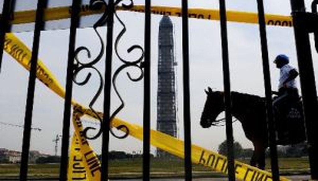A mounted police officer passes in front of the Washington Monument and the World War II memorial on the Mall in Washington during a federal shutdown on Oct. 3, 2013.