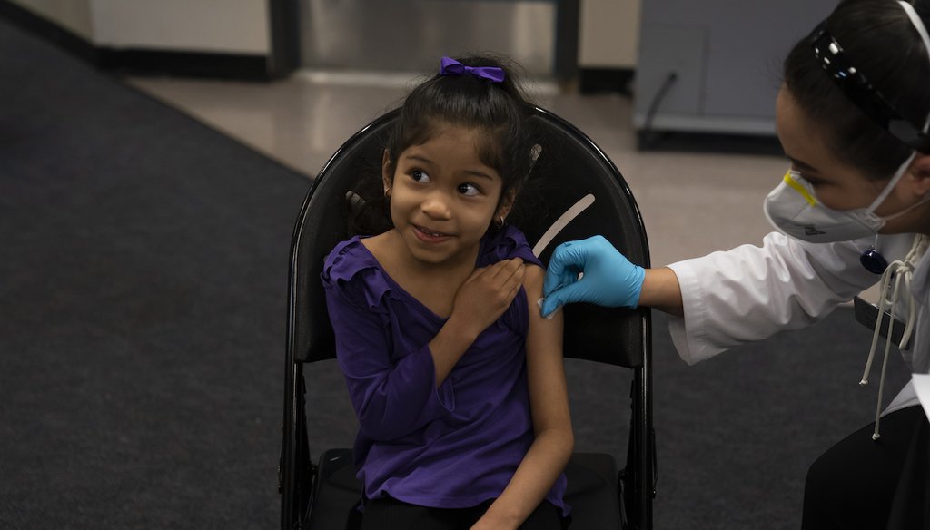 Elsa Estrada, 6, smiles at her mother as a pharmacist applies an alcohol swab to her arm before administering the Pfizer COVID-19 vaccine at a pediatric clinic for children set up at Willard Intermediate School in Santa Ana, Calif. Tuesday, Nov. 9, 2021.