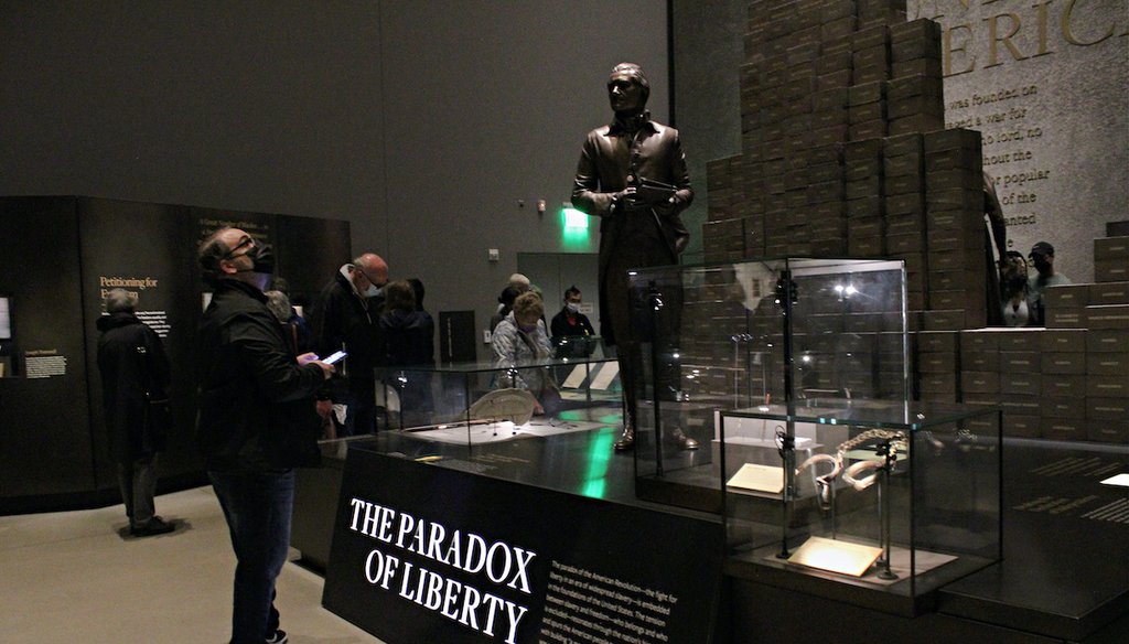 A visitor at the National Museum of African American History and Culture in Washington, D.C. stands in front of a statue of Pres. Thomas Jefferson, Oct. 29, 2021. (Gabrielle Settles/PolitiFact)