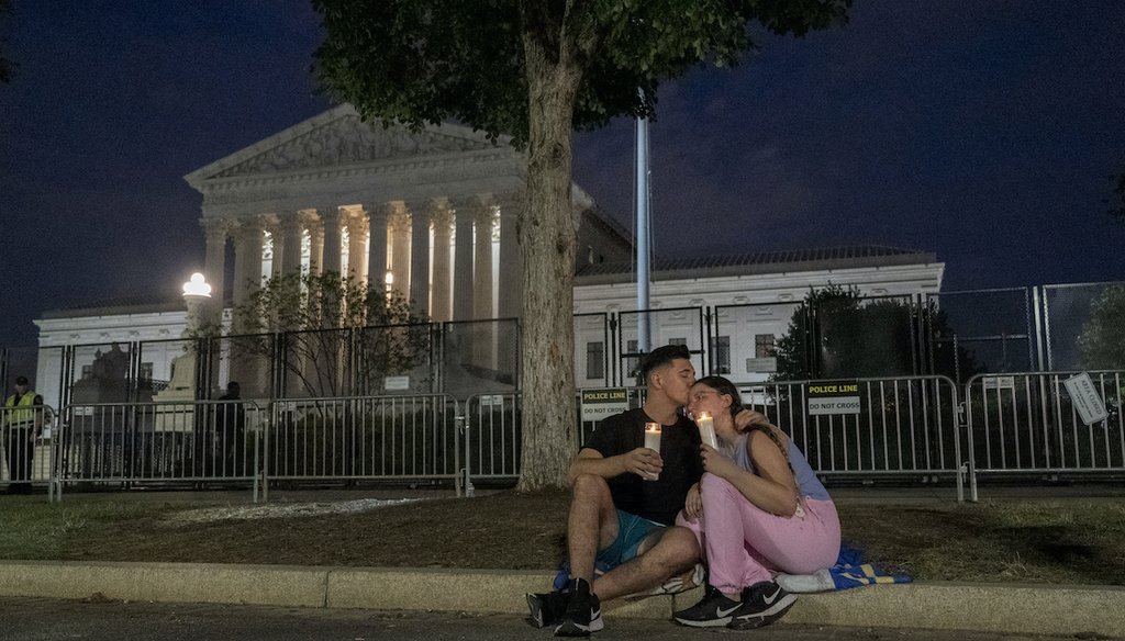 An abortion-rights protester comforts another during a candlelight vigil for reproductive freedom and abortion rights outside the Supreme Court in Washington on June 26, 2022. (AP)