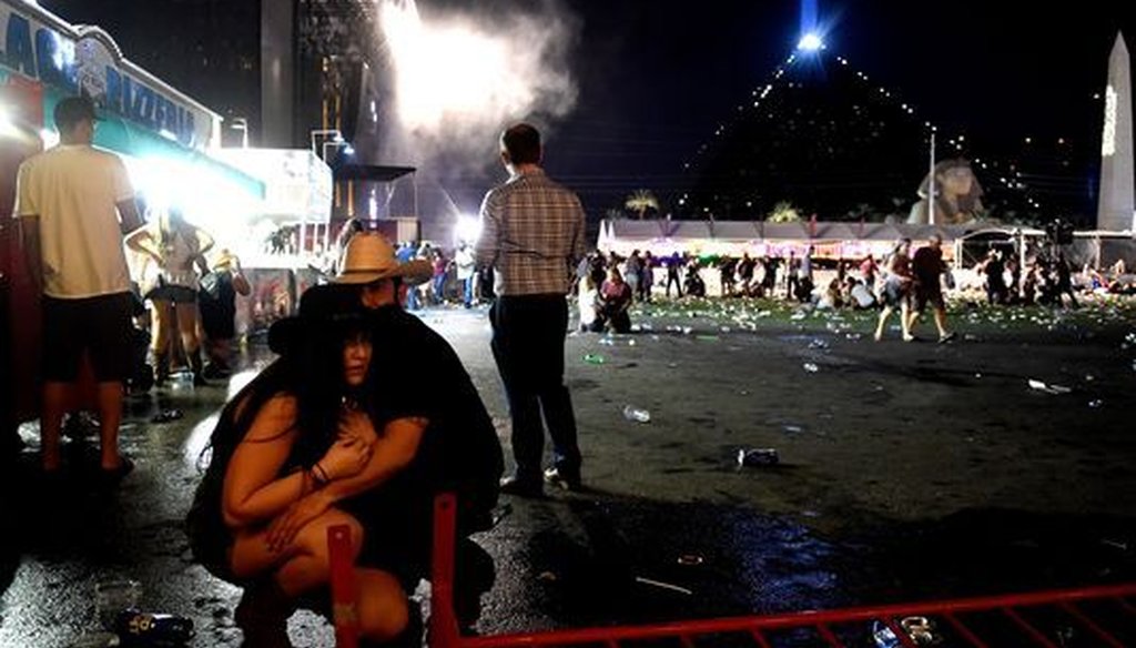 People take cover after hearing gunfire at a country music festival, the scene of the mass shooting. (David Becker/Getty Images
