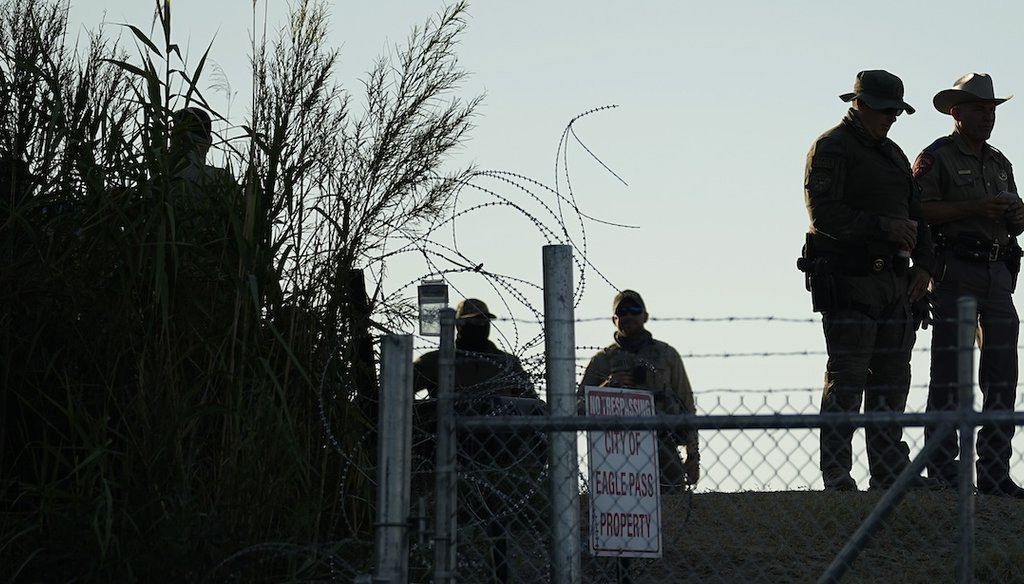 Texas troopers stand near a "No Trespassing" sign and concertina wire along the banks of the Rio Grande at Shelby Park, Aug. 1, 2023, in Eagle Pass, Texas. (AP)