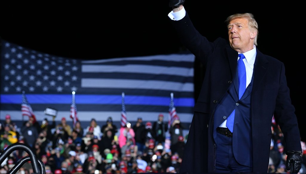 President Donald Trump waves as he leaves a campaign rally at Waukesha County Airport in Waukesha, Wisconsin on October 24, 2020. A large Thin Blue Line flag is visible behind the president.(Getty Images).