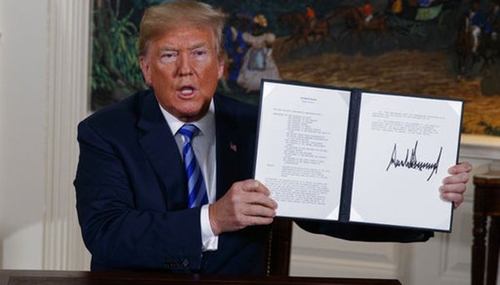 President Donald Trump shows a signed presidential memorandum after delivering a statement on the Iran nuclear deal from the White House on May 8, 2018. (AP/Evan Vucci)