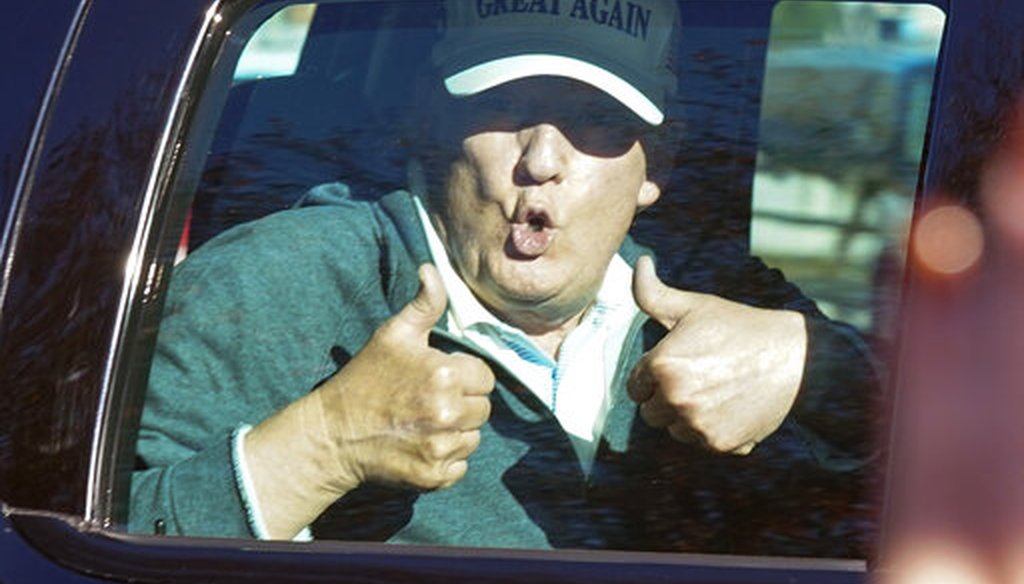 President Donald Trump gives two thumbs up to supporters as he departs after playing golf at the Trump National Golf Club in Sterling Va., Sunday Nov. 8, 2020.