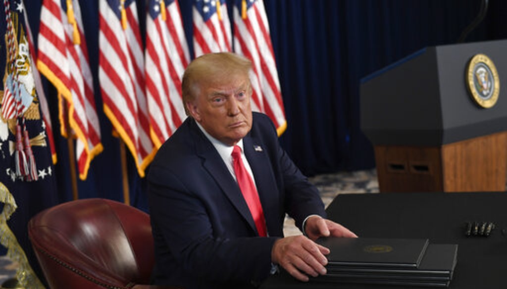 President Donald Trump prepares to sign four executive orders during a news conference at the Trump National Golf Club in Bedminster, N.J., Saturday, Aug. 8, 2020. (AP Photo)