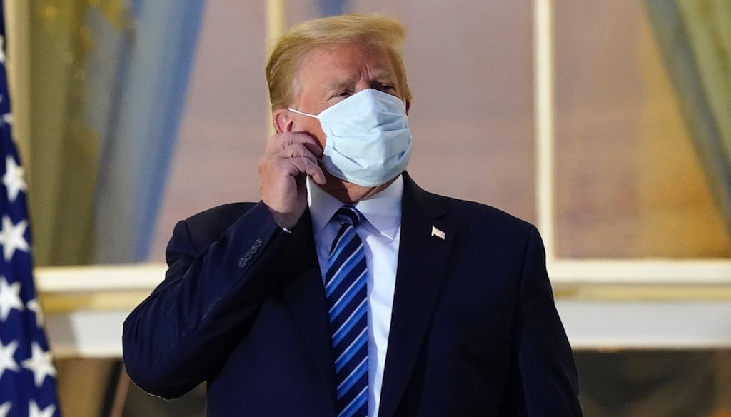 President Donald Trump removes his mask on his return to the White House  after leaving Walter Reed National Military Medical Center, in Bethesda, Md.  (AP Photo/Alex Brandon)