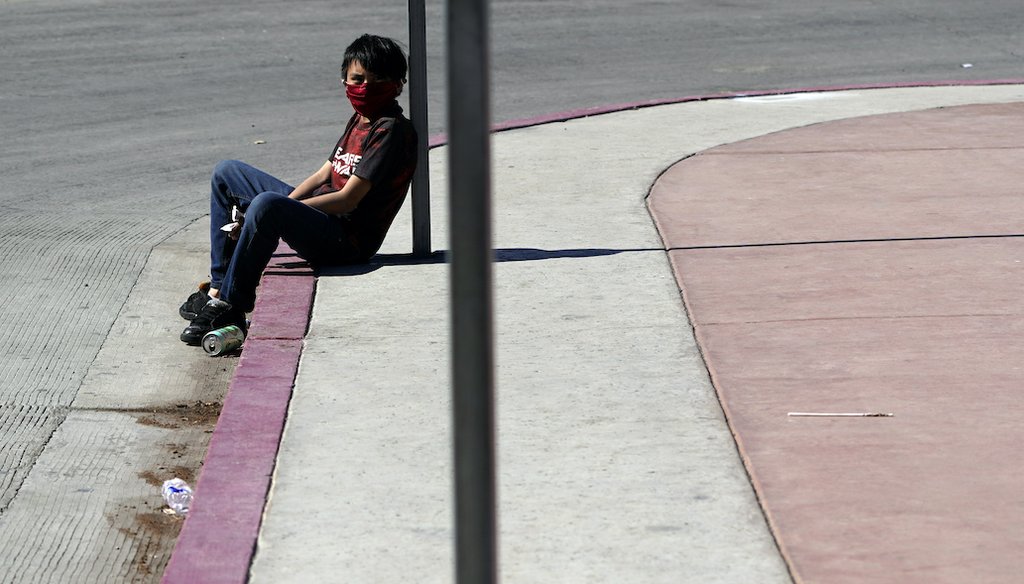 In this Monday, March 1, 2021 photo, a boy sits near where tents used by migrants seeking asylum in the United States line an entrance to the border crossing, in Tijuana, Mexico. (AP)