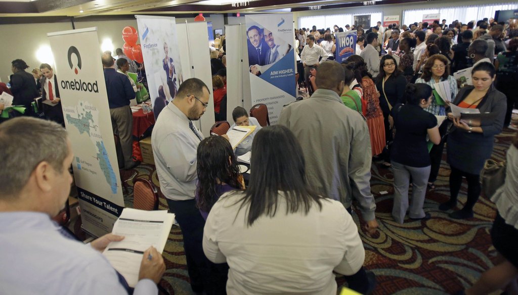 Job seekers check out companies at a job fair in Miami Lakes, Fl. on Aug. 14, 2013. Photo credit: AP.